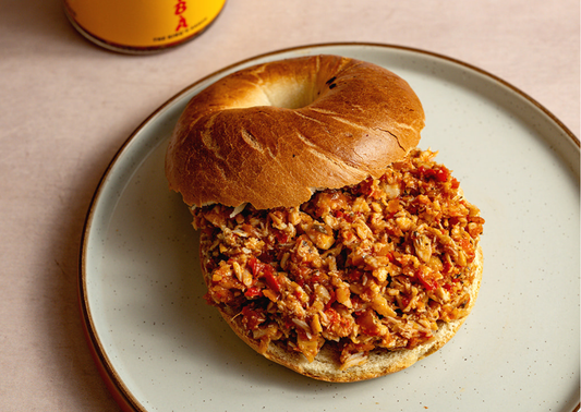 TOMÁTÌ ỌBÀ spiced tuna bagel on a ceramic plate